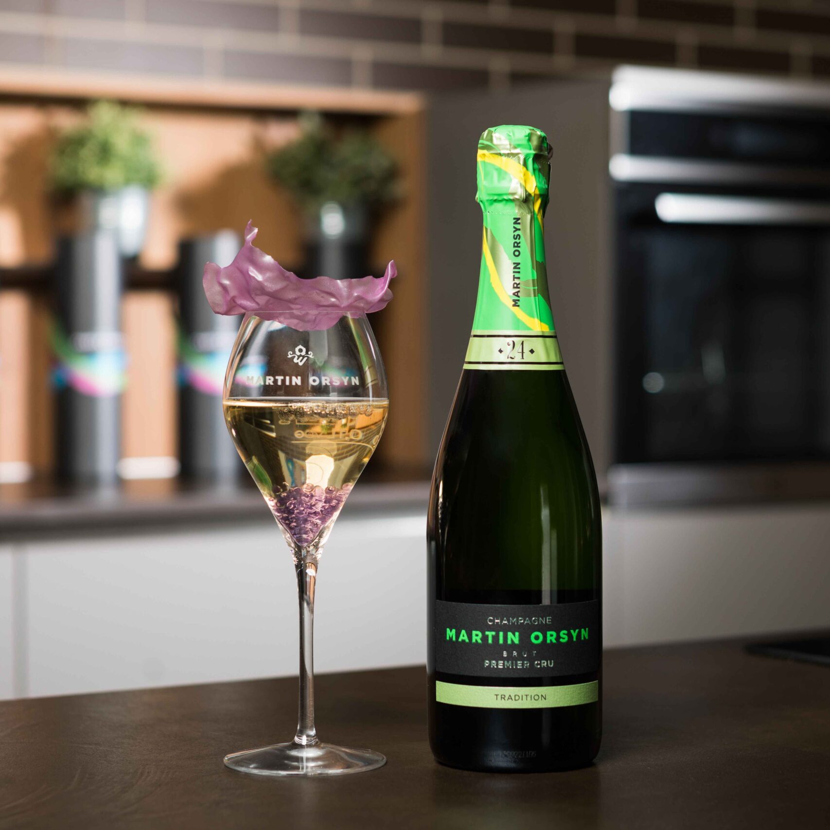 Bottiglia e calice di champagne su tavolo cucina.